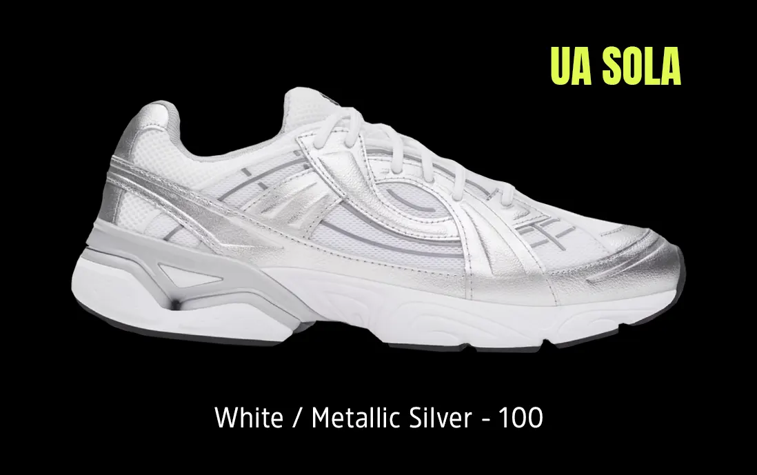 Tenis Under Armour Sola en color blanco, diseño minimalista y detalles en metálico.